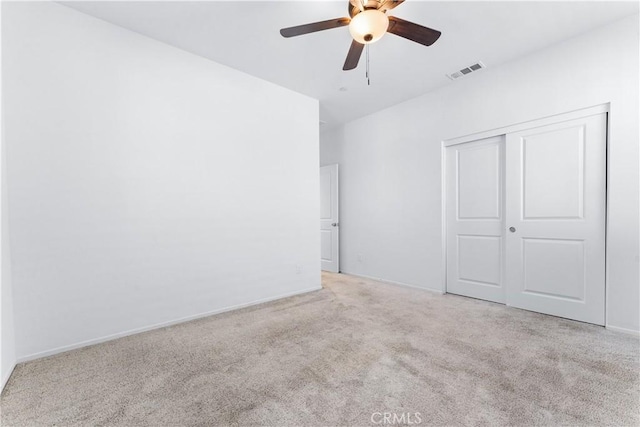 unfurnished bedroom featuring baseboards, visible vents, ceiling fan, carpet flooring, and a closet