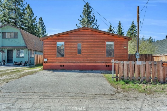 view of side of property featuring crawl space and fence