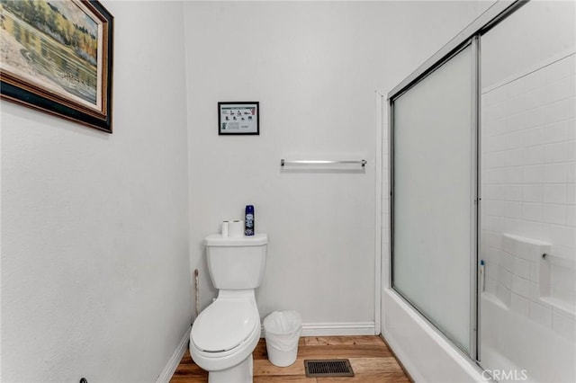 full bathroom featuring toilet, wood finished floors, visible vents, and baseboards