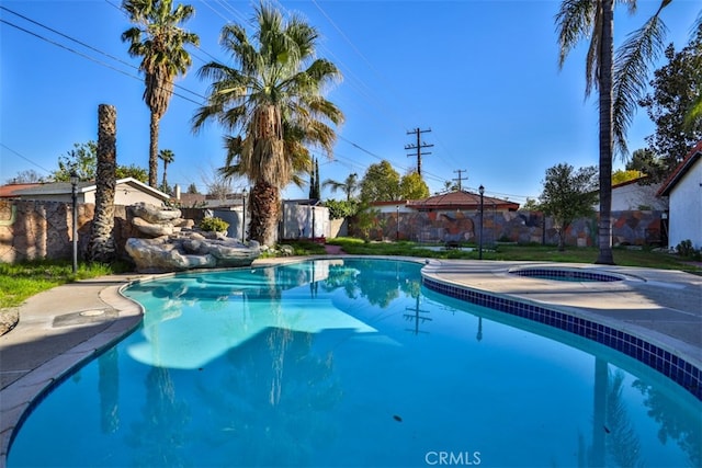 view of swimming pool featuring an in ground hot tub, a fenced backyard, and a fenced in pool