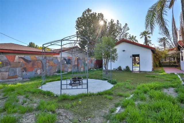 view of yard with a patio, an outdoor fire pit, and fence