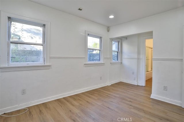 spare room with recessed lighting, light wood-type flooring, and baseboards