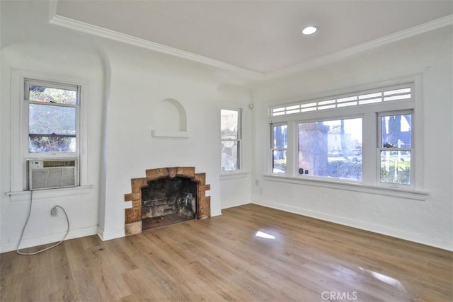 unfurnished living room featuring cooling unit, a fireplace, wood finished floors, plenty of natural light, and crown molding