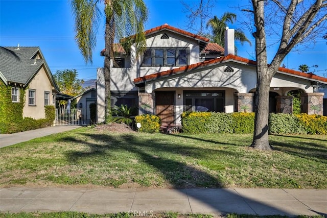 view of front facade featuring a front lawn, a chimney, a tile roof, and stucco siding