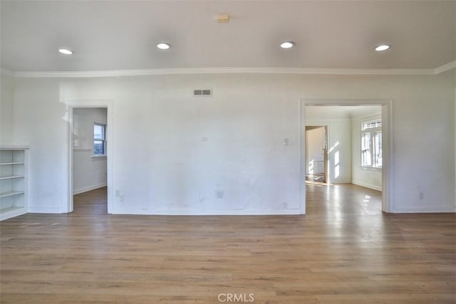 unfurnished room with light wood-style flooring, recessed lighting, visible vents, baseboards, and ornamental molding