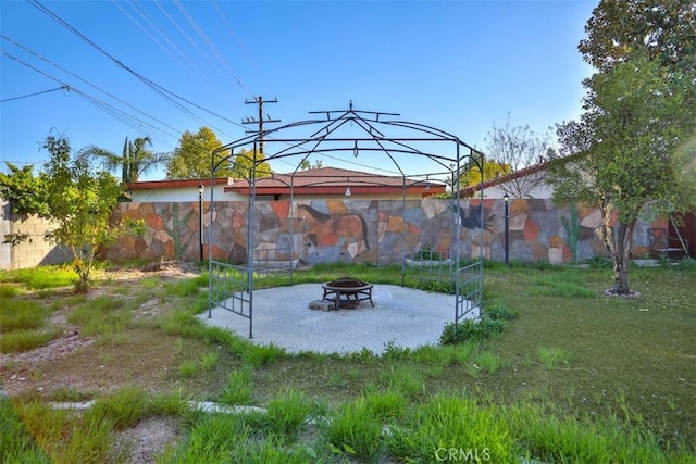 view of yard featuring an outdoor fire pit and fence