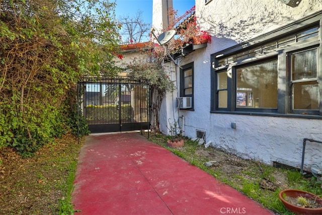 3255 N Arrowhead Ave, San Bernardino, CA 92405 - view of home's exterior with stucco siding, a gate, and cooling unit
