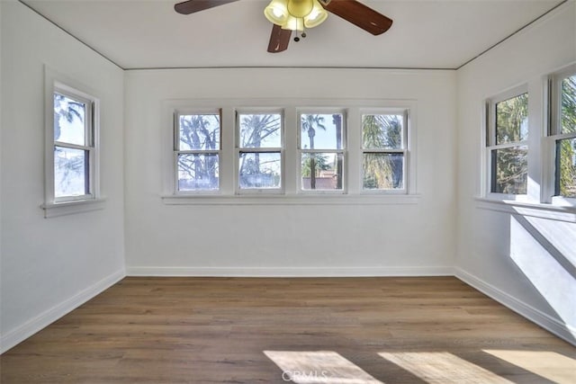 unfurnished room with a ceiling fan, baseboards, and wood finished floors