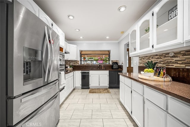 kitchen with ornamental molding, appliances with stainless steel finishes, glass insert cabinets, and white cabinets