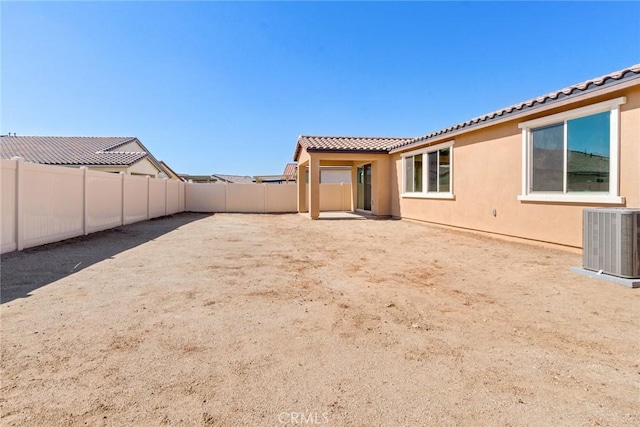 12945 Big Valley Ct, Riverside, CA 92503 - back of house with central air condition unit, a fenced backyard, stucco siding, and a tile roof