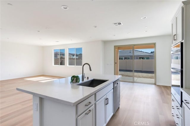 12945 Big Valley Ct, Riverside, CA 92503 - kitchen featuring light wood-style floors, visible vents, appliances with stainless steel finishes, light countertops, and a sink