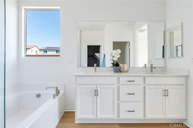 12945 Big Valley Ct, Riverside, CA 92503 - full bath with a sink, double vanity, wood finished floors, and a garden tub