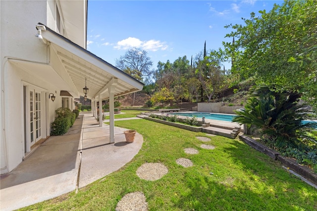 view of yard featuring an outdoor pool, french doors, and a patio