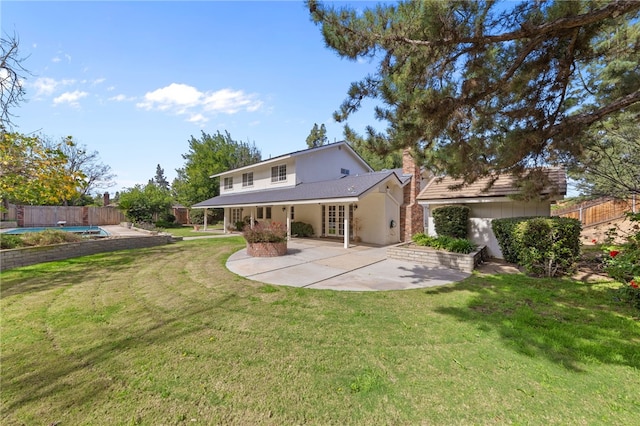 back of property featuring a fenced in pool, a patio, a lawn, and fence