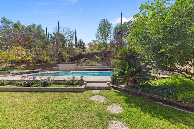 outdoor pool featuring a yard