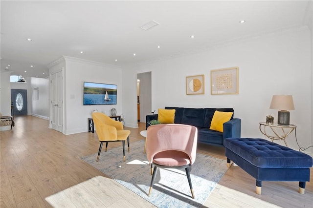 living room with baseboards, recessed lighting, light wood-type flooring, and crown molding