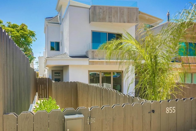 view of front of property with a gate, fence, and stucco siding