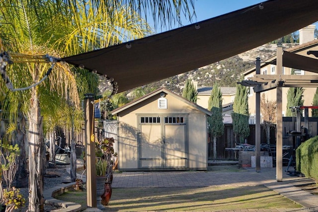 garage featuring fence and a storage shed