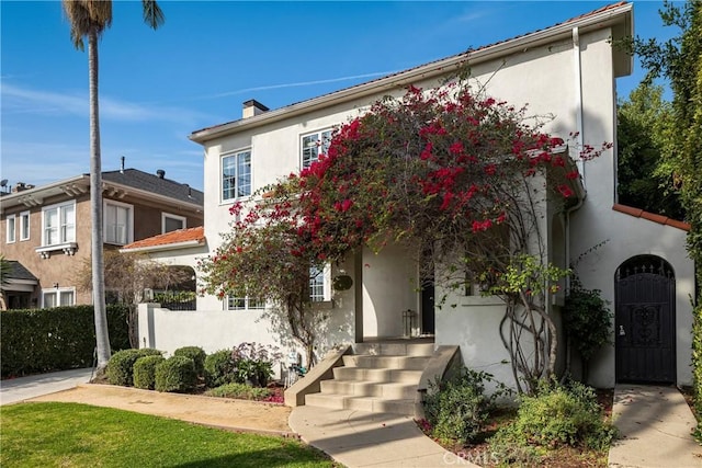 view of front of property featuring a chimney and stucco siding