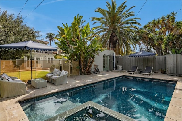 view of swimming pool featuring an outbuilding, a patio area, a fenced backyard, and a fenced in pool