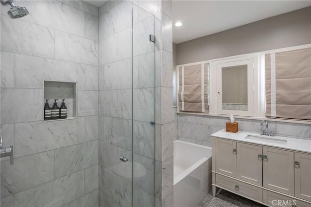 bathroom featuring a stall shower, vanity, tile walls, and a bath