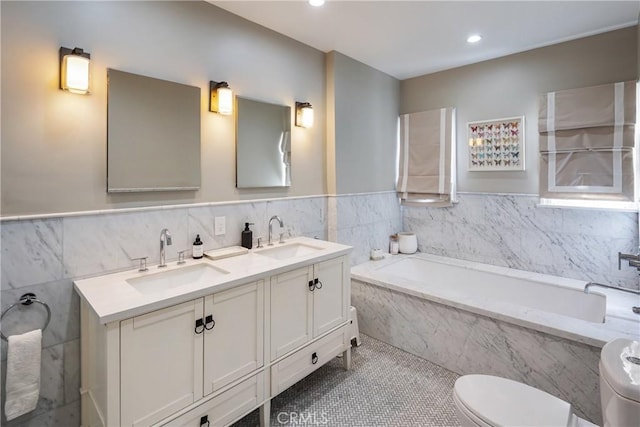 full bath featuring a garden tub, a sink, toilet, and double vanity