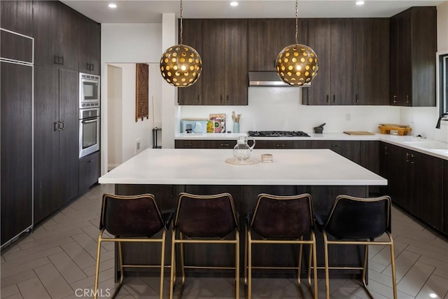 kitchen featuring light countertops, a breakfast bar, a sink, and appliances with stainless steel finishes