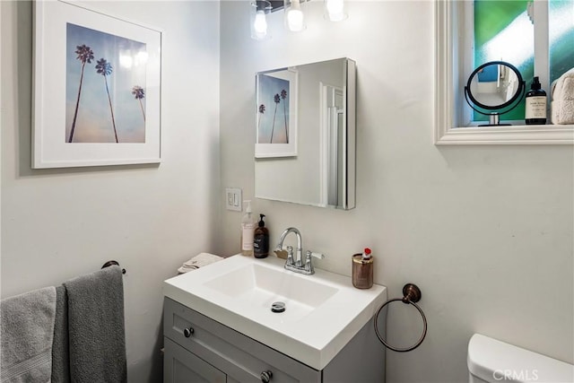 half bathroom with vanity and toilet