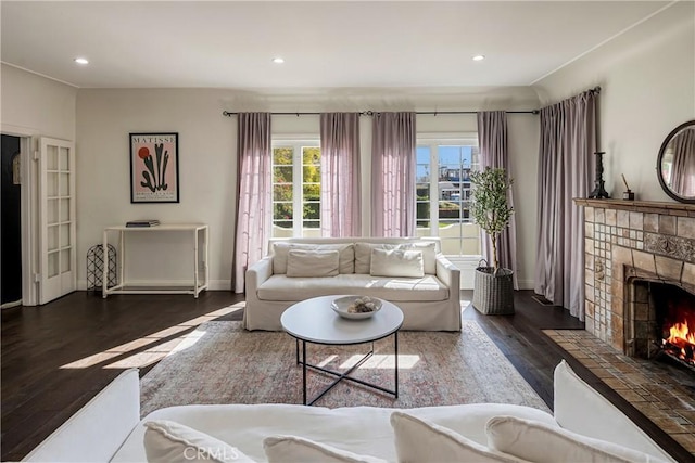 living room with baseboards, a tiled fireplace, wood finished floors, and recessed lighting