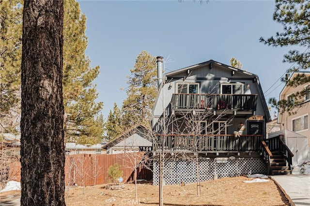 back of house with fence and a wooden deck