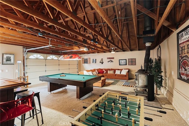 game room featuring a garage, a wood stove, carpet flooring, and billiards