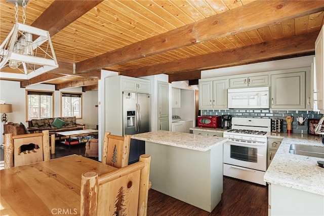 kitchen featuring white appliances, wooden ceiling, a center island, independent washer and dryer, and backsplash