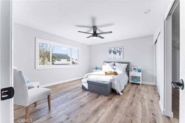 bedroom featuring ceiling fan, light wood-type flooring, and baseboards