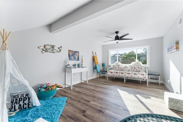 interior space featuring baseboards, visible vents, ceiling fan, wood finished floors, and vaulted ceiling with beams