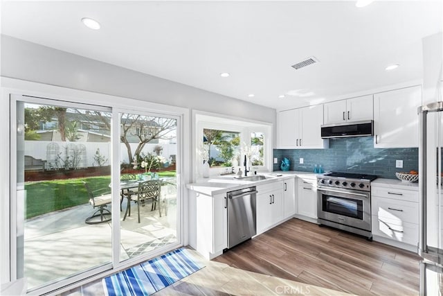 kitchen featuring a sink, backsplash, stainless steel appliances, and light countertops