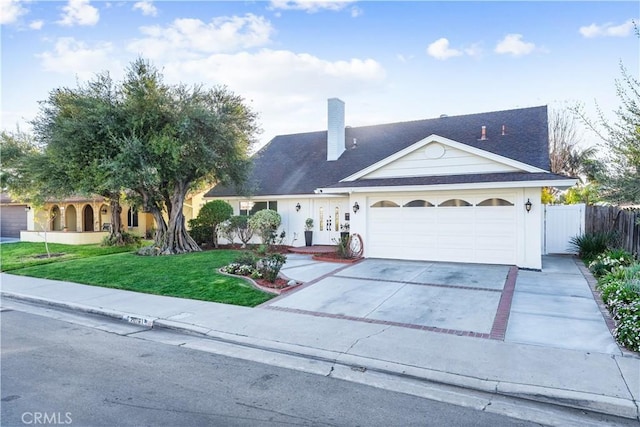 view of front facade with a garage, driveway, fence, and a front yard