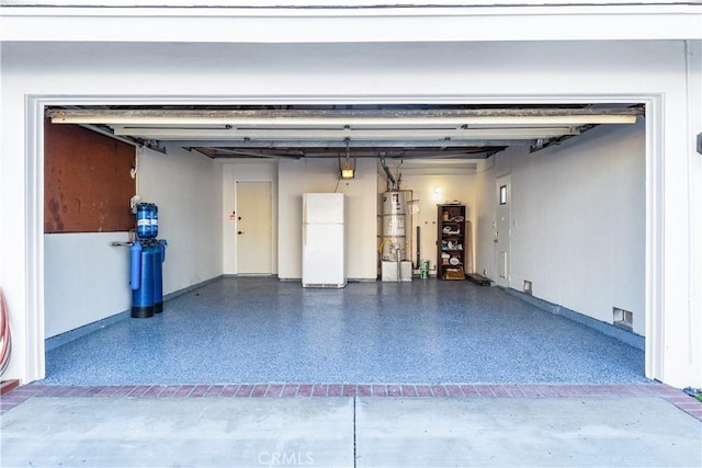 garage with water heater and freestanding refrigerator