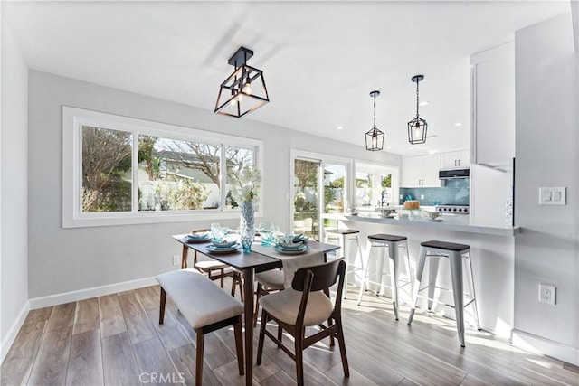 dining space featuring recessed lighting, wood finished floors, and baseboards