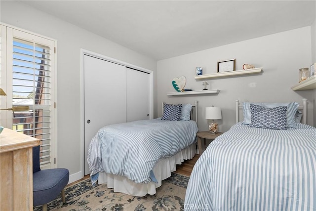 bedroom featuring a closet, wood finished floors, and baseboards