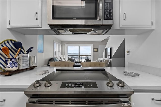 kitchen with open floor plan, light countertops, appliances with stainless steel finishes, and white cabinets