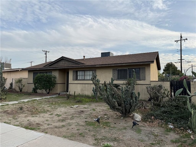 view of front facade featuring fence and stucco siding