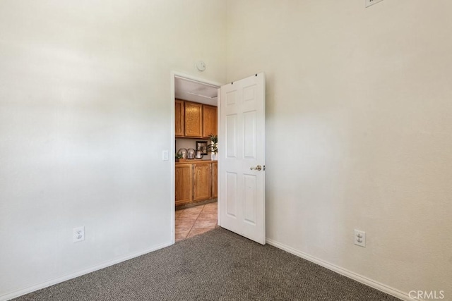 spare room featuring baseboards and light colored carpet