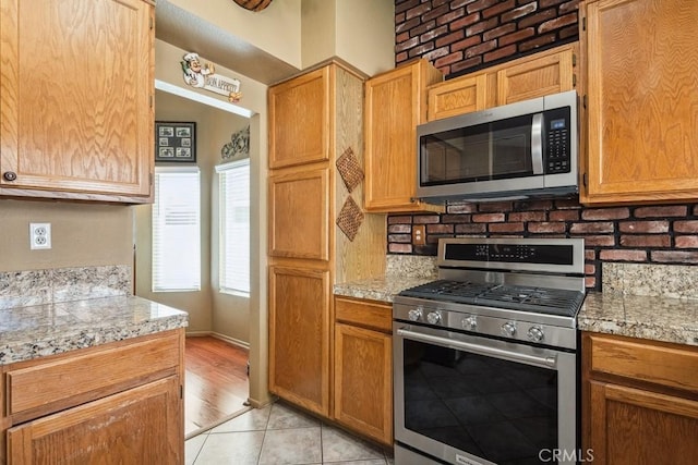 kitchen with appliances with stainless steel finishes, light countertops, and light tile patterned floors