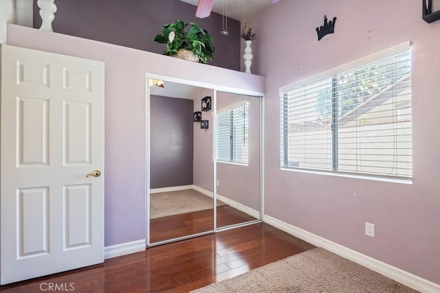 unfurnished bedroom with a closet, baseboards, and wood finished floors