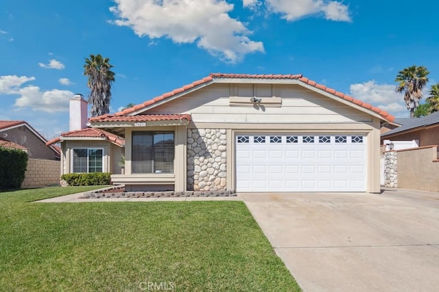 view of front of house featuring a garage, a tile roof, driveway, a chimney, and a front yard