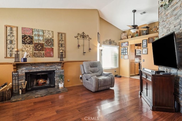 living room with ceiling fan, a fireplace, visible vents, and wood finished floors