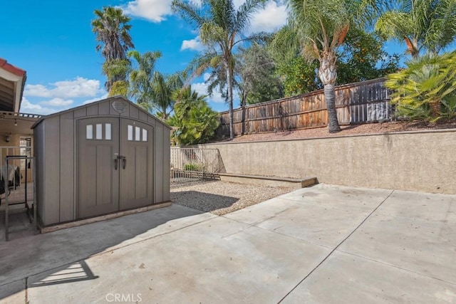 view of yard with a storage shed, a patio area, a fenced backyard, and an outdoor structure