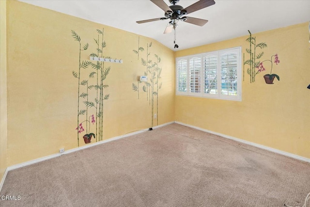 carpeted empty room with ceiling fan and baseboards