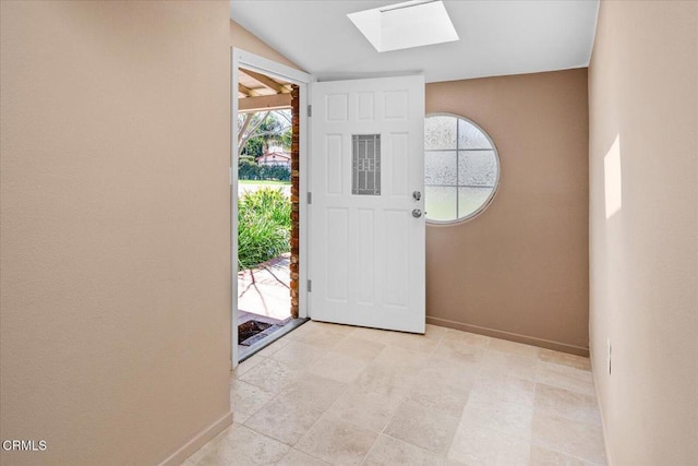 foyer with lofted ceiling with skylight and baseboards