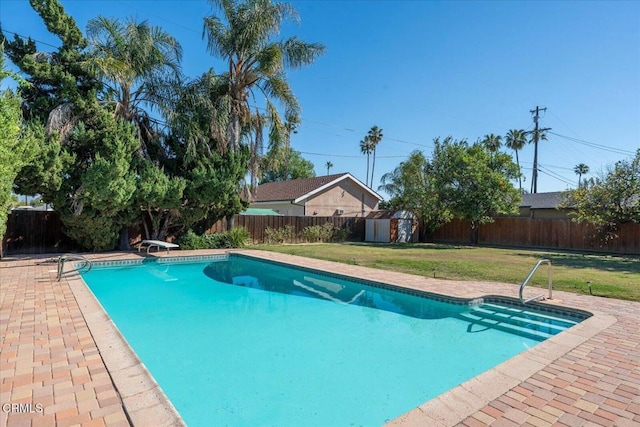 view of pool with a fenced in pool, a fenced backyard, a yard, an outdoor structure, and a patio area